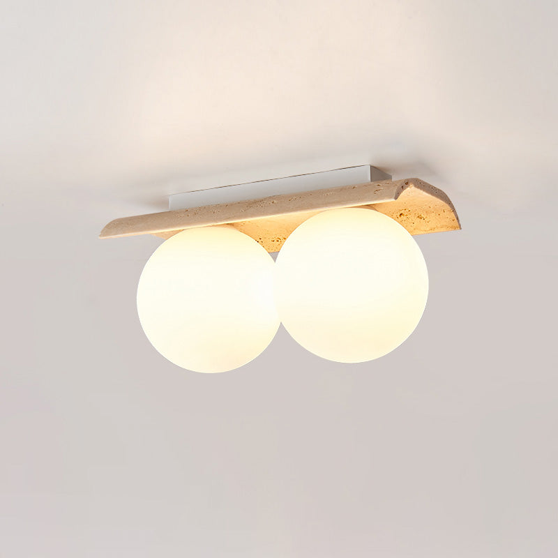 Serenaya lámpara de techo con globo de vidrio y cuerpo de travertino