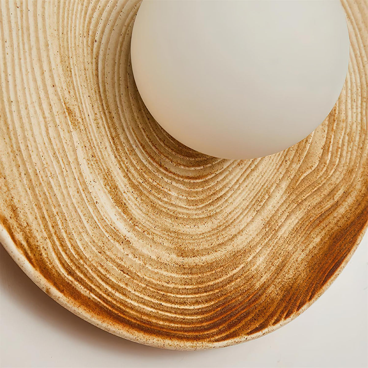 Aplique de pared moderno con disco de cerámica texturizada y acentos de madera