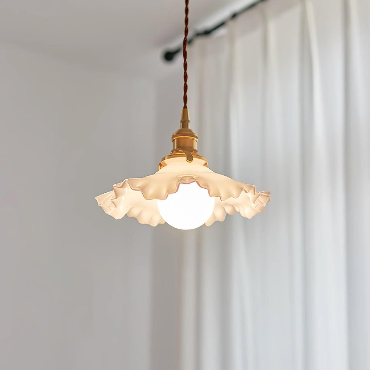 Lámpara colgante de vidrio con pliegues y florón de latón, luz cálida