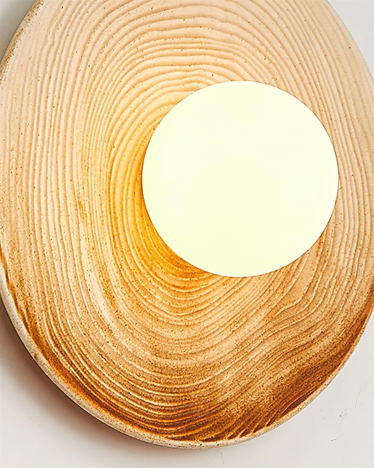 Aplique de pared moderno con disco de cerámica texturizada y acentos de madera