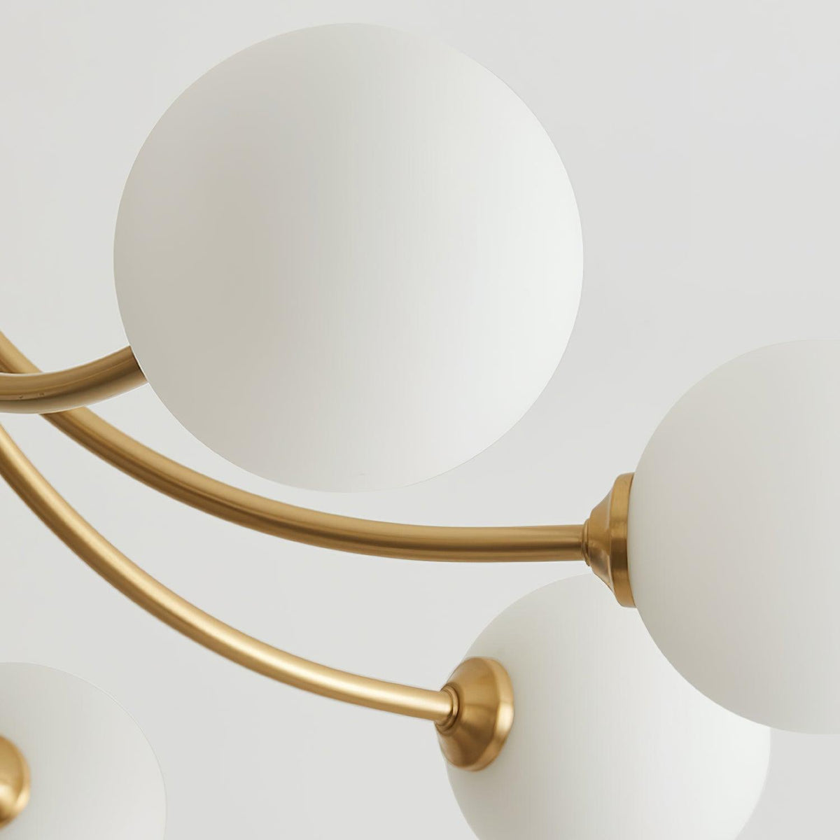 Lámpara de techo moderna con brazos en latón y globos opalinos esfera